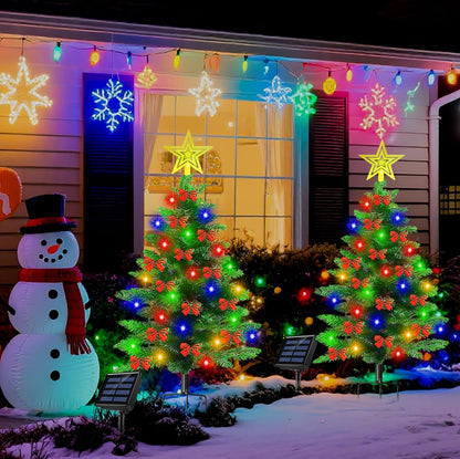 Solar Christmas trees glowing on a front porch at night
